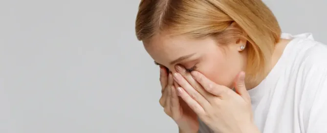 A woman rubbing her eyes