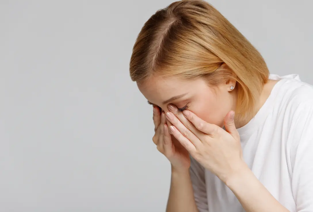 A woman rubbing her eyes