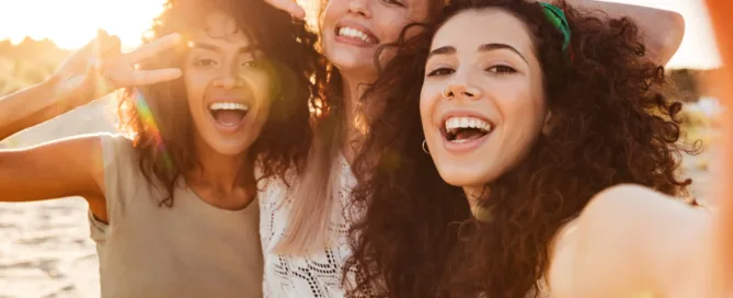 A group of happy young girls smiling while standing closely, relaxed and cheerful