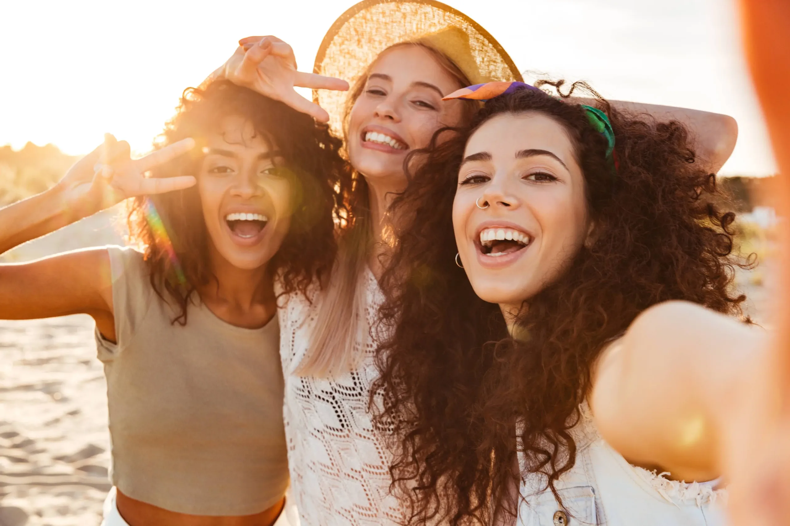 A group of happy young girls smiling while standing closely, relaxed and cheerful