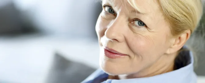 A woman in professional wear, looking at the camera with a cheerful smile