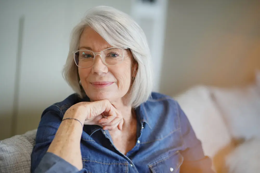 Smiling woman with glasses at an ophthalmology clinic