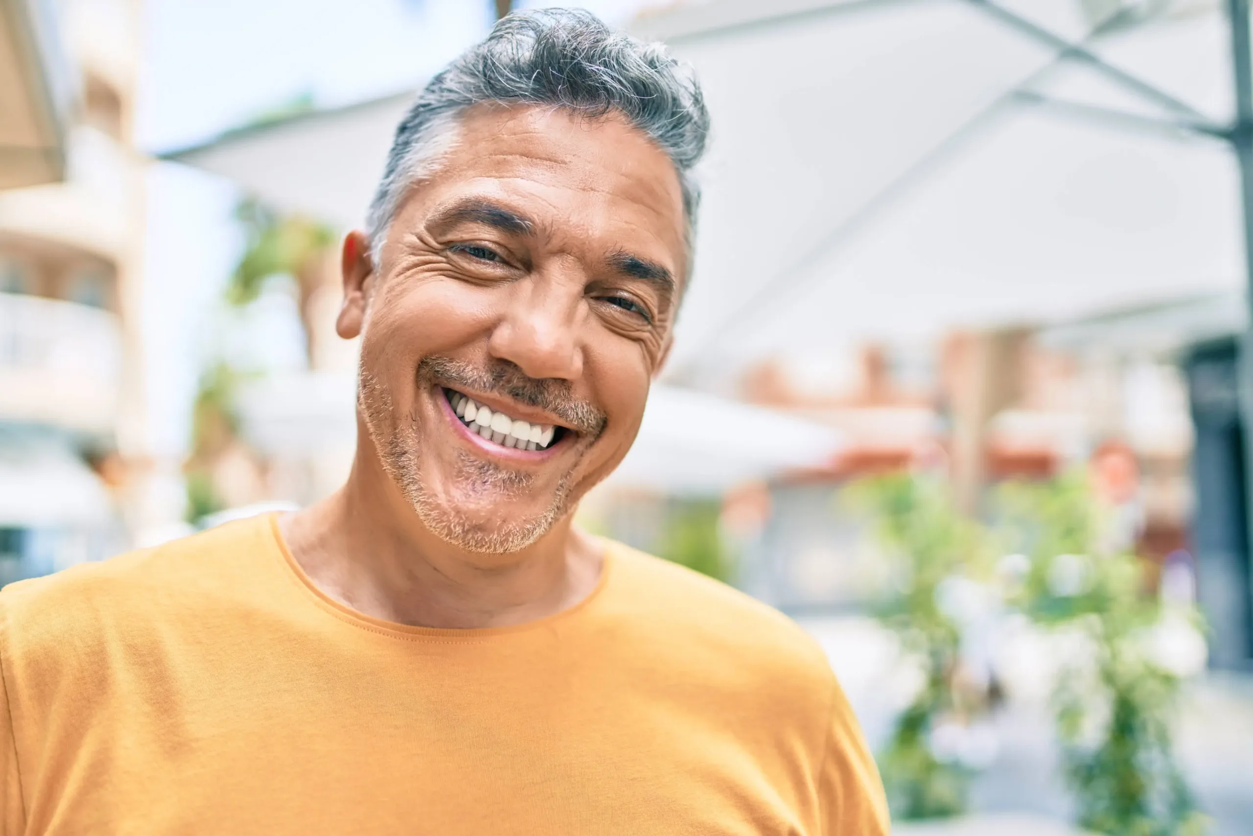 A man smiling with a friendly expression, casually dressed