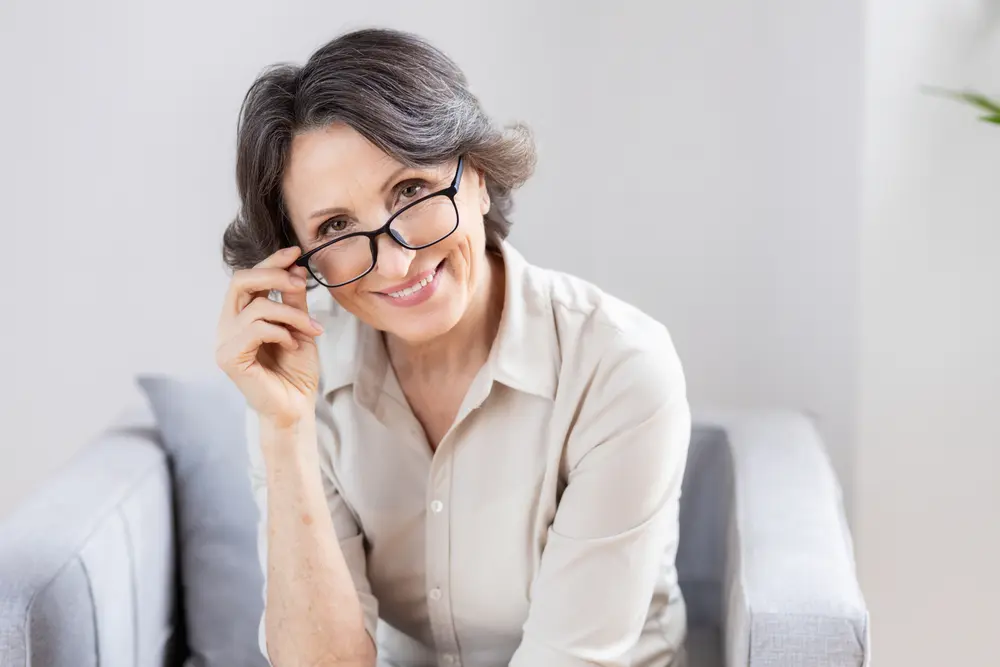 Smiling woman with glasses at an ophthalmology clinic