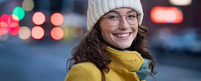 A woman in winter wear, looking at the camera with a cheerful smile