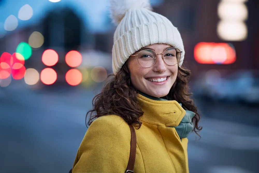 A woman in winter wear, looking at the camera with a cheerful smile