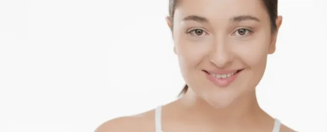 A woman smiling with a friendly expression, casually dressed