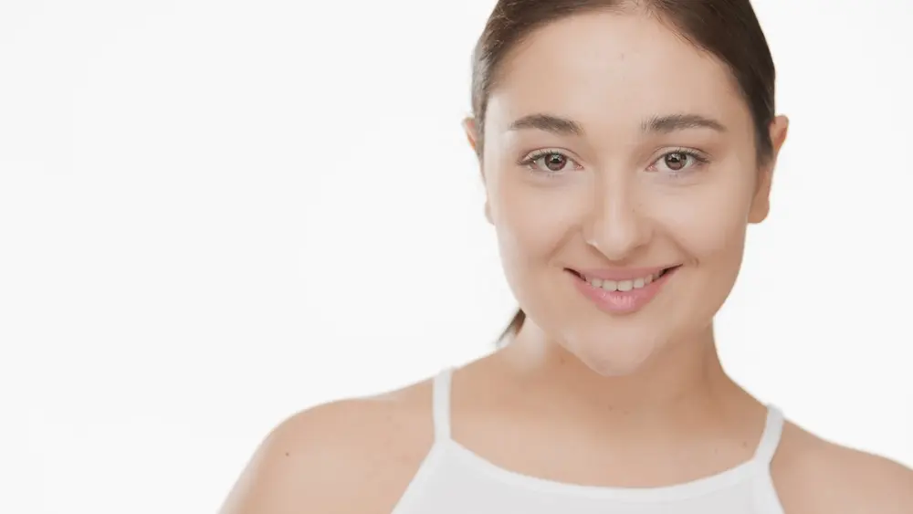 A woman smiling with a friendly expression, casually dressed