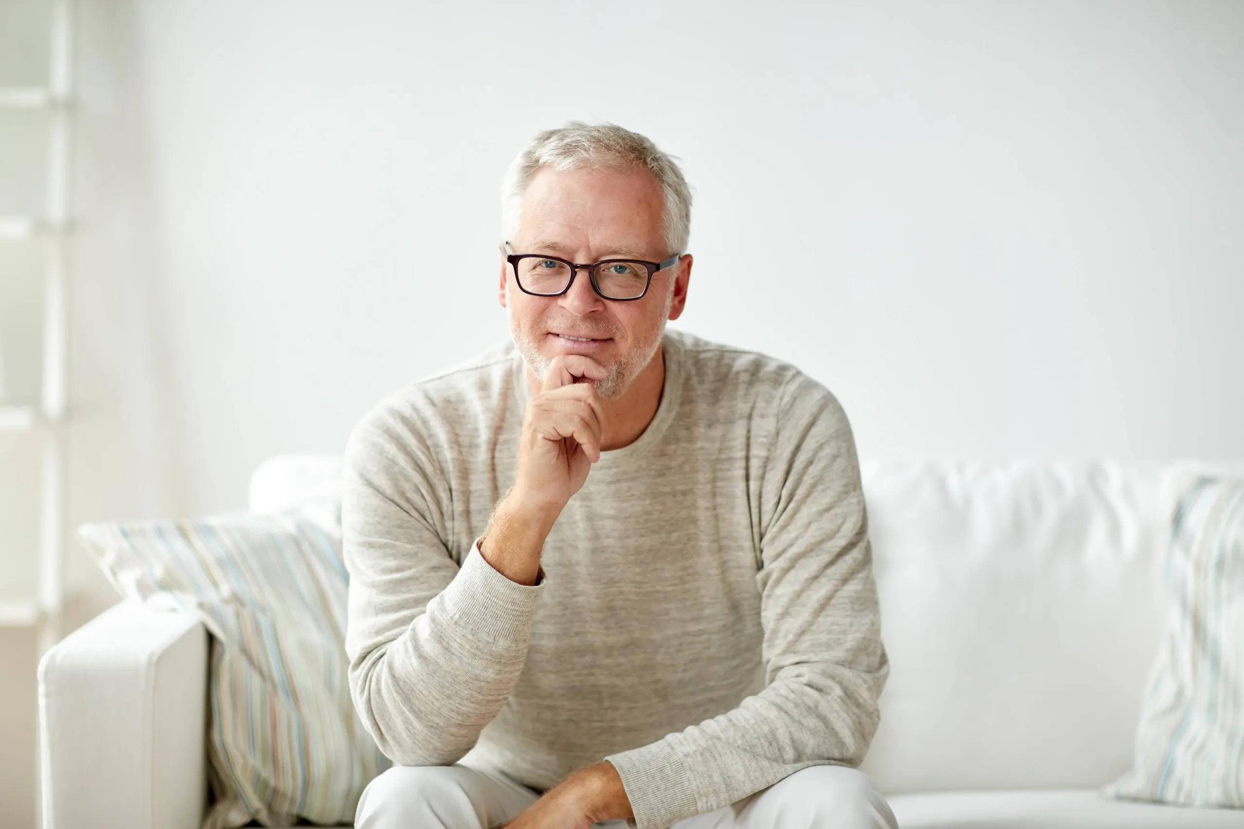 A man wearing glasses who ios smiling with a friendly expression, casually dressed